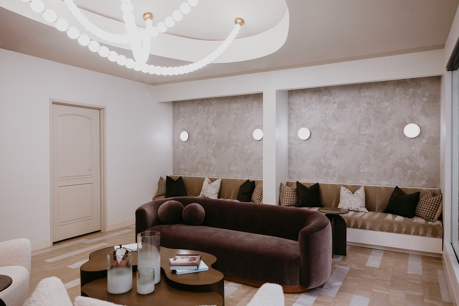 Modern luxurious waiting room with plum velvet sofa and chandelier